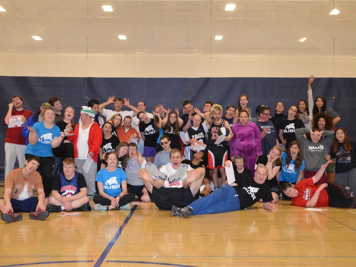 A group of students, Gonzaga basketball players, and adults with disabilities playing basketball together.
